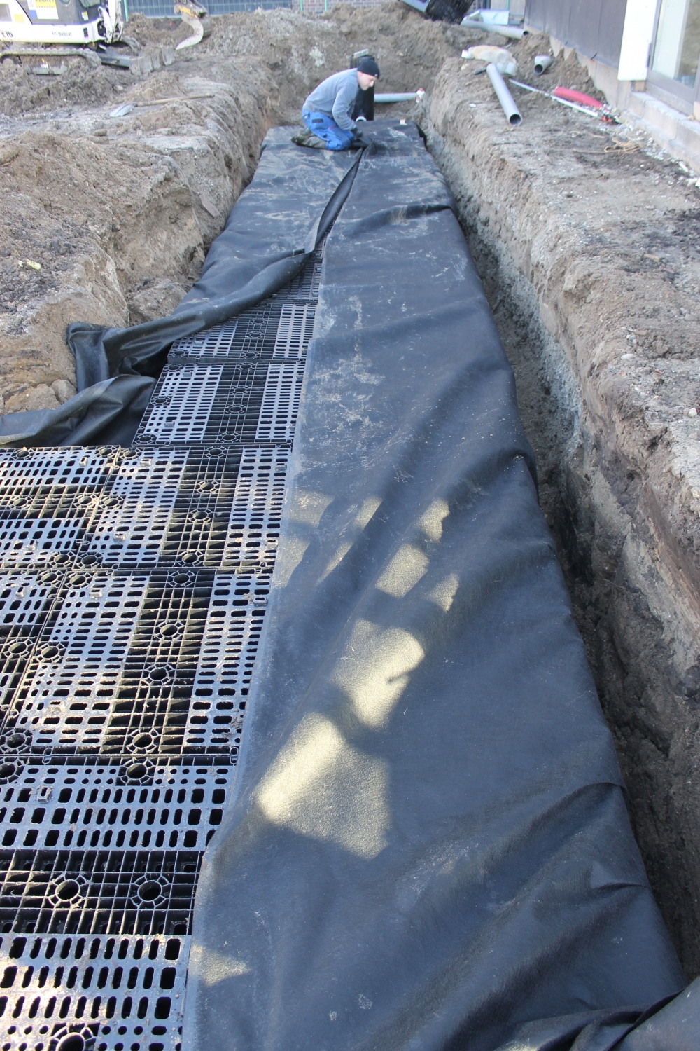 Omsluiten van het geotextiel om de infiltratiekratten Sikkofix